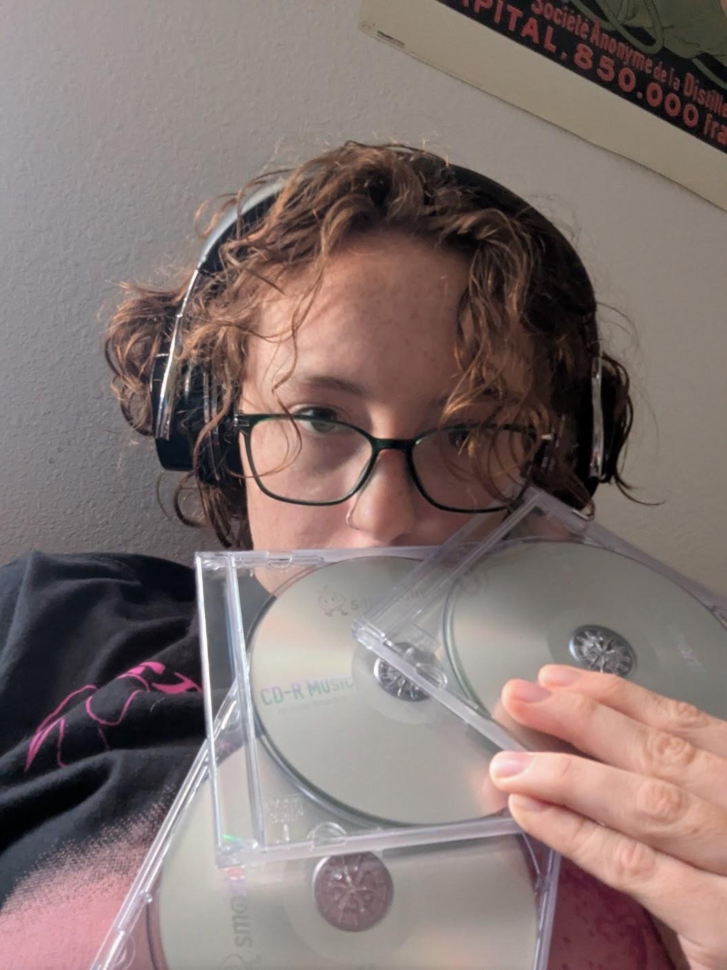 they/them grandson holding blank CDs